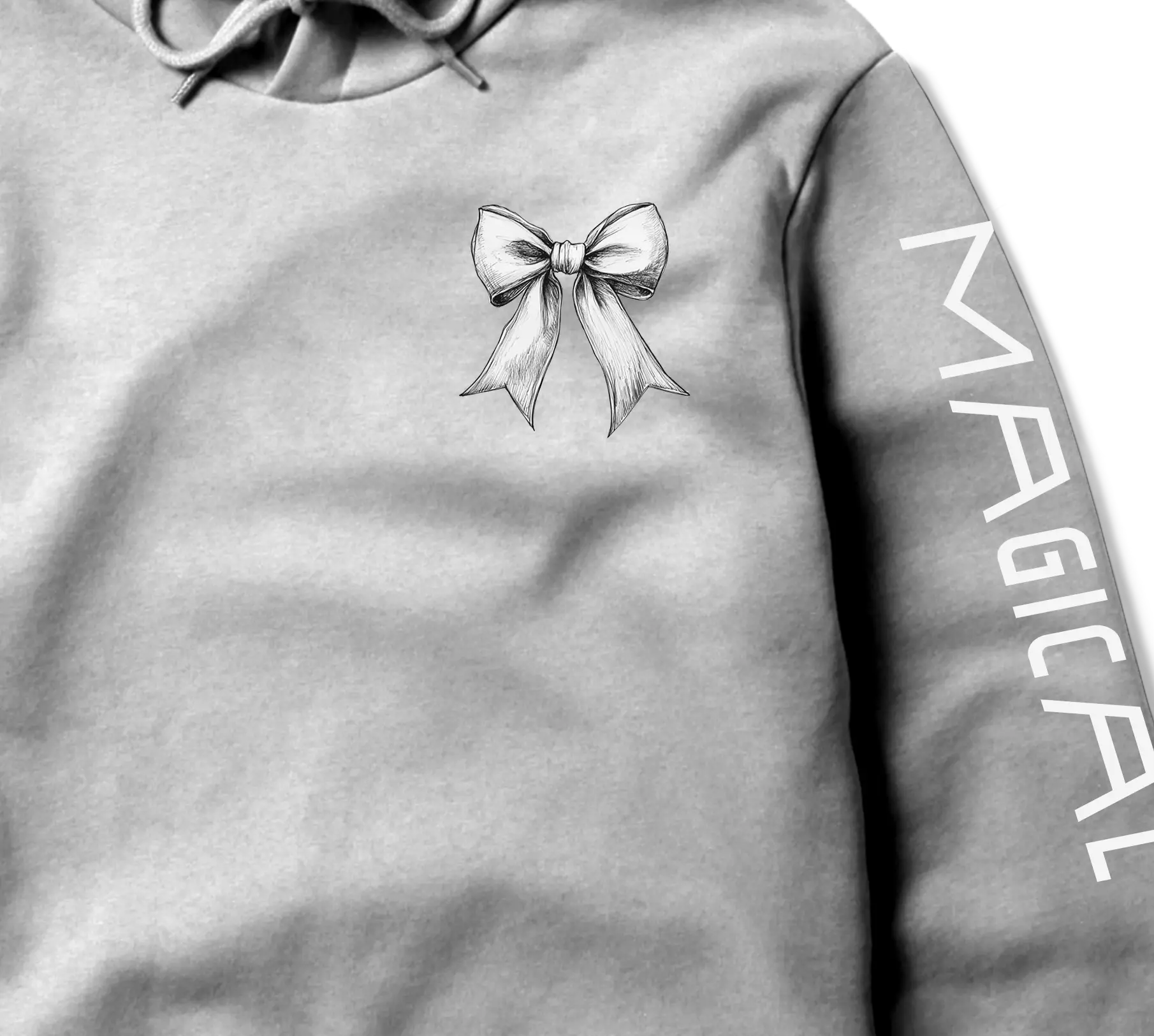 Gray cropped hoodie with a delicate bow design on the chest and ‘MAGICAL’ text printed on the sleeve.