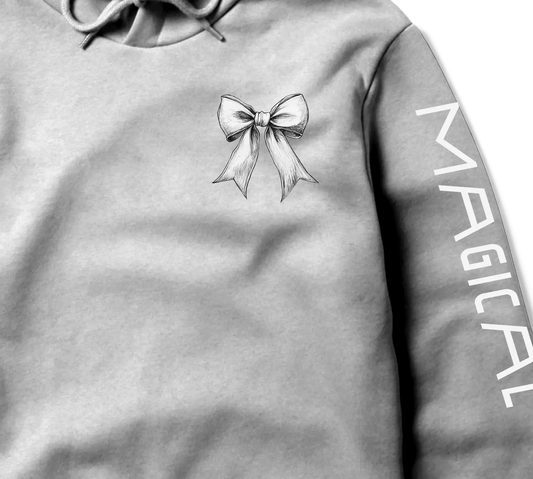 Gray cropped hoodie with a delicate bow design on the chest and ‘MAGICAL’ text printed on the sleeve.