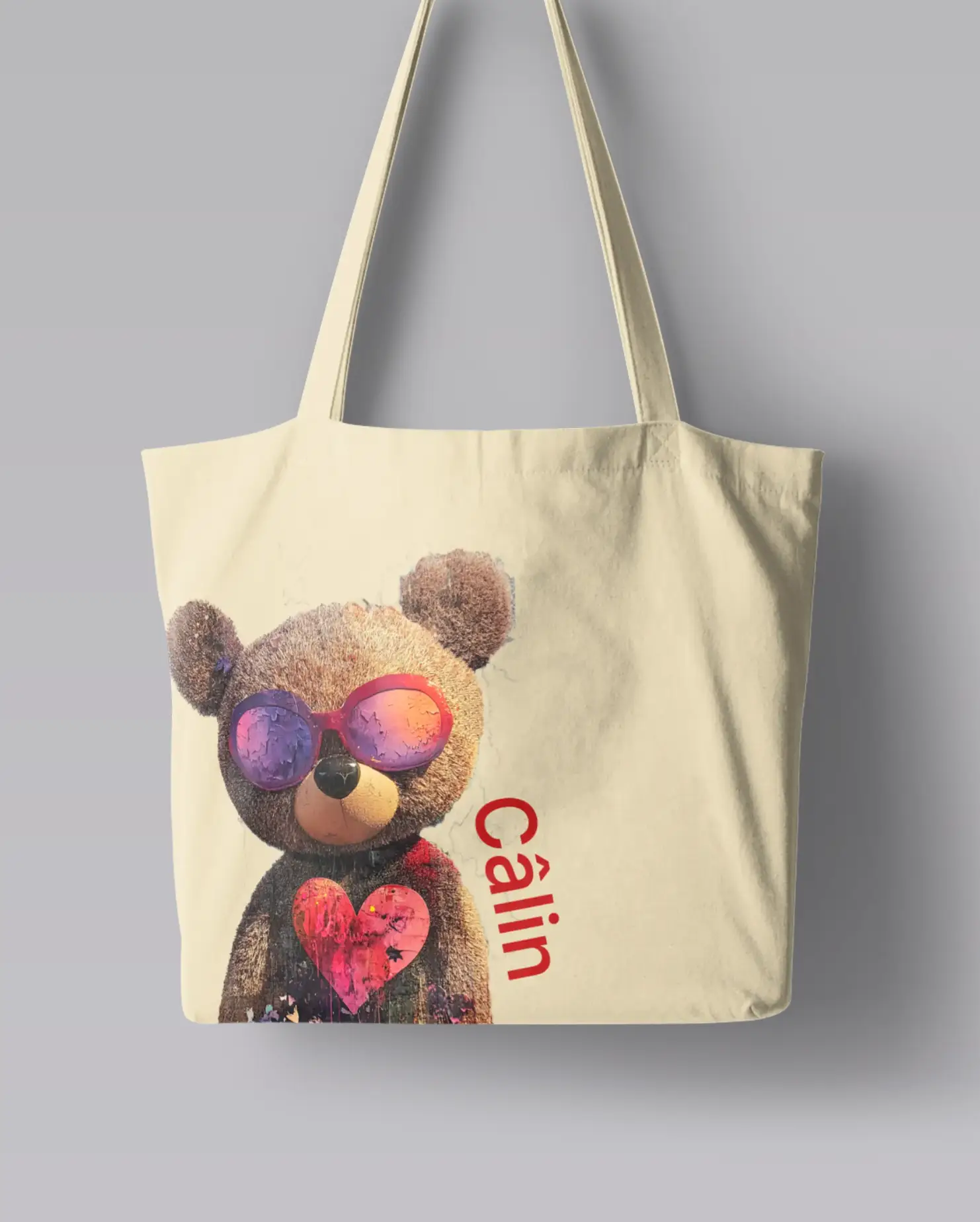 Câlin Tote bag featuring an adorable teddy bear wearing sunglasses and holding a heart, with ‘Câlin’ text written along the side, symbolizing love and care.