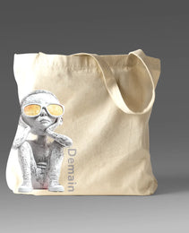 Demain Tote bag featuring a captivating design of a boy in sunglasses gazing upward, symbolizing hope, curiosity, and connection to the future, with ‘Demain’ text printed along the side.